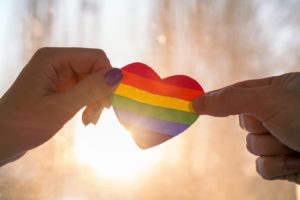 A close up of two hands holding a rainbow heart against the light of the sun. LGBTQ therapy in Grand Rapids, MI can offer support for the LGBTQ community. Learn more by contacting an LGBTQ therapist in Grand Rapids, MI or search "LGBTQ therapist near me" to learn more. 