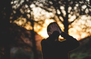 A man covers his face with his hands as he appears to struggle internally. This could represent the pain of anxiety that an anxiety therapist in Grand Rapids, MI can address. Learn more about anxiety treatment in Grand Rapids, MI and other services. 