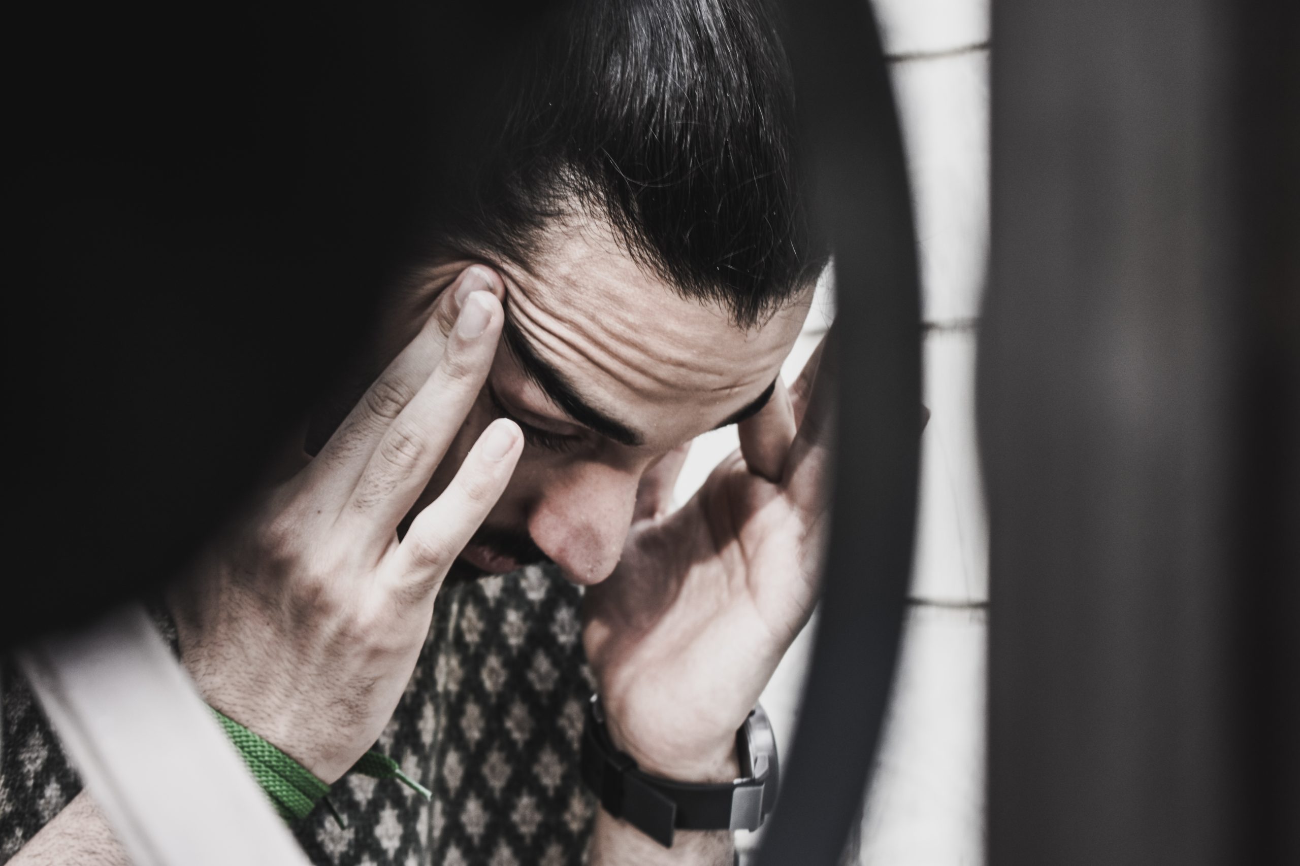 A man holds his temples with an anxious expression. This could represent the anxiety of ending a relationship. Learn how couples therapy in Grand Rapids, MI can offer support with deciding if it is time. Contact a couples therapist in Kent County, MI to learn more about couples therapy in Grand Rapids, MI today.