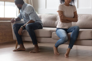 A couple sit on a couch angled away from one another. Couples therapy in Grand Rapids, MI can offer support for your relationship. Learn more about couples therapy in Kent County, MI and other services by contacting a couples therapist in Grand Rapids, MI today.