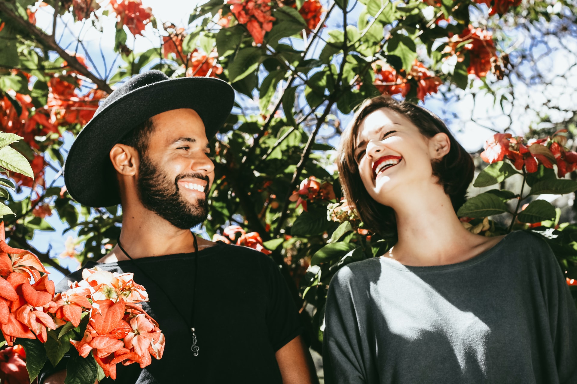 A couple smile with one another while standing surrounded by flowers. Learn more how couples therapy in Kent County, MI can offer support. Contact a couples therapist in Grand Rapids, MI to learn how couples therapy and marriage counseling in Kent County, MI can support you. 
