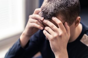 Image of a Teen covering their face. Does your teen need help coping with the stresses of every day life and responsibilities. Online therapy for teens in Kent County, Michigan is the help they need today! 